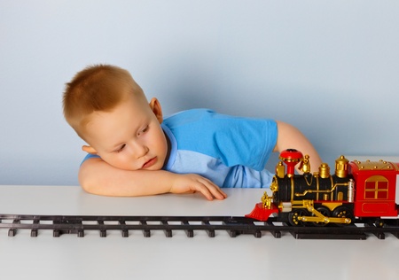Little boy playing with a toy locomotive at homeの写真素材