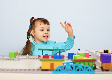 A child plays with a toy railroad on tableの写真素材