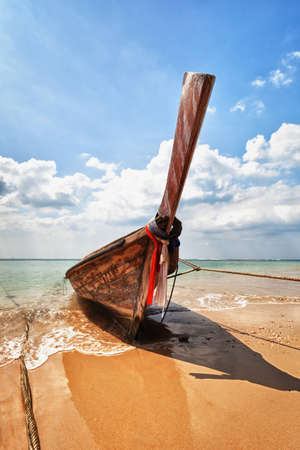 Old wooden traditional boat on the tropical beach - Thailandの写真素材