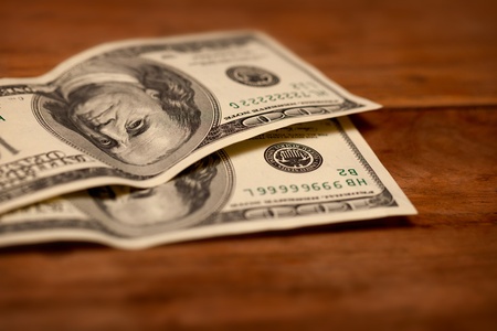 Dollars on wooden table close up. Shallow depth of fieldの写真素材