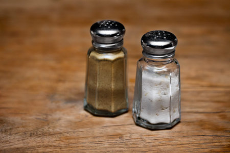 Saltshaker and pepper shaker on a wooden table. Shallow depth of fieldの写真素材