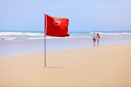 Tropical beach and a red flag. Swimming is forbidden!の写真素材