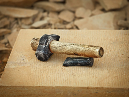 Old grunge used hammer and metal boaster on limestone stone wall 