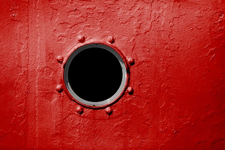 Porthole on the red wall of the old shipの写真素材