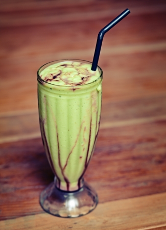 Fruit shake in a glass on the table - an exotic green drink.の写真素材