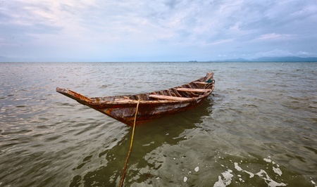 Empty old wooden boat on the waves close upの写真素材