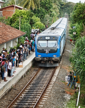 BENTOTA, SRI LANKA - APR 28: Train arrive to station with people on Apr 28, 2013 in Bentota, Sri Lanka. Trains are becoming more popular transport due to railway improvement by government. のeditorial素材