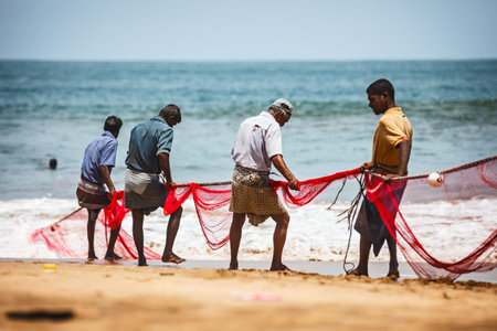 BENTOTA, SRI LANKA - 26 APR 2013: Sri Lankan fishermen pull big net in Bentota, Sri Lanka. Fishing...