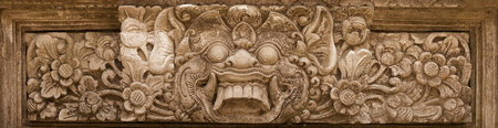 Terrible mythical monster face. Stone relief from Indonesia, Bali island