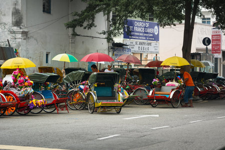 MALAYSIA, PENANG, GEORGETOWN - CIRCA JUL 2014: Cycle rickshaws or pedicabs lined up and waiting for...
