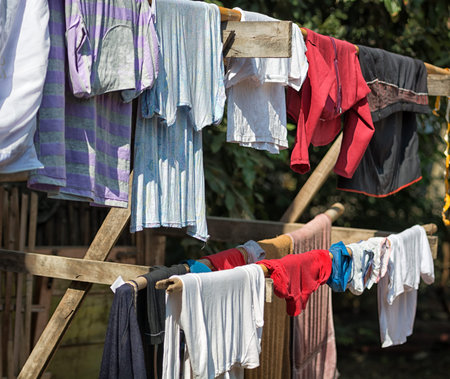 Colorful clothes drying on the wooden stick. Countryside scene
