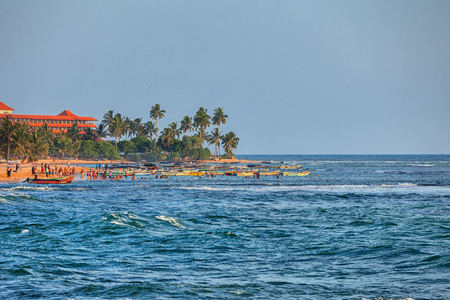 HIKKADUWA, SRI LANKA - CIRCA APR 2013: Beach near the hotel. Sunny day, palm trees, sand and people batheのeditorial素材