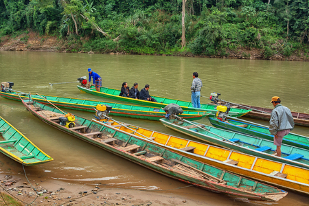 LUANG PRABANG, LAOS - CIRCA DEC 2013: Boaters carry passengers on a small riverのeditorial素材