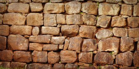 Wall assembled from a roughly processed natural stone. The Backgroundの写真素材
