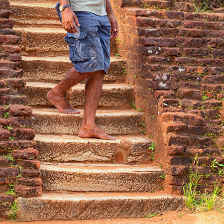 Local man walks down the old stone steps. Sri Lankaの写真素材