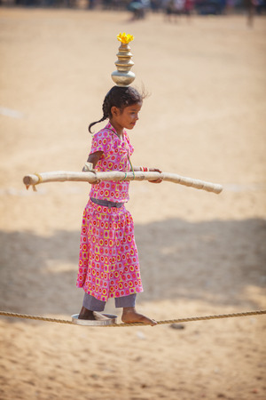 PUSHKAR, RAJASTHAN, INDIA - CIRCA NOV 2012: Child Circus Entertainer Performs on a Tightrope in Pushkarのeditorial素材