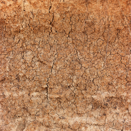 Extreme closeup of reddish, clay soil, cracking, crumbling and eroding under very dry conditions.の写真素材