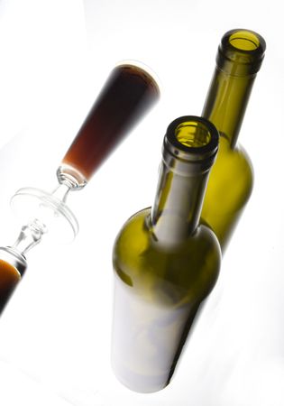 A glass of beer and a bottle in high key lighting on a mirrorの写真素材