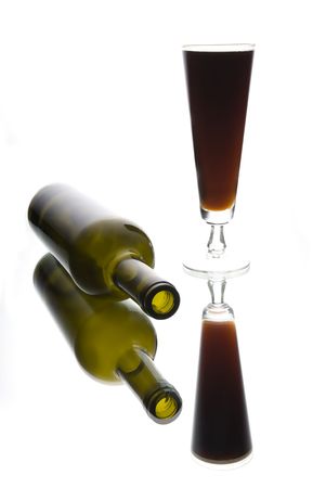 A glass of beer and a bottle in high key lighting on a mirrorの写真素材