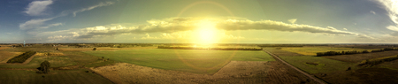 Aerial panoramic of the sun and clouds over South Dakota farmland in the summer.の写真素材