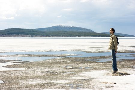 The frozen lake and the person ashoreの写真素材