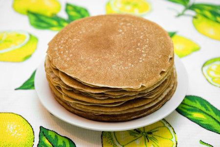 Hill from pancakes on white plate on bright cloth