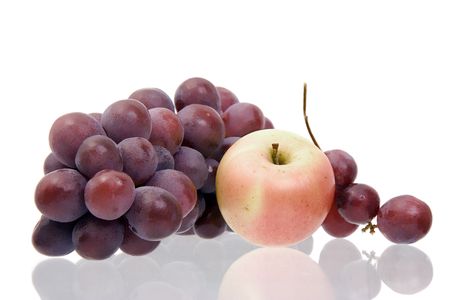 Still-life with grapes and an apple on a white background with reflexionの写真素材