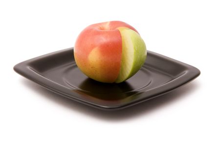 Apple and its segment on a black plate on a white backgroundの写真素材
