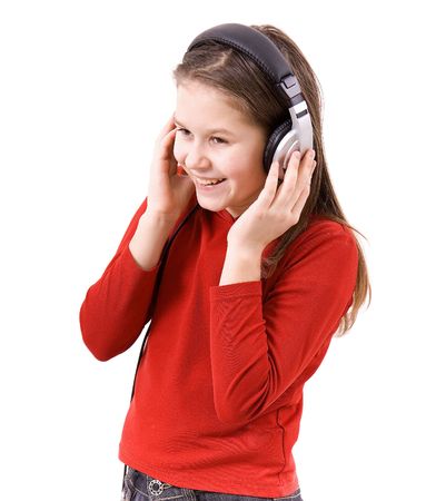 On white background the girl in the big ear-phones listens to music and smilesの写真素材