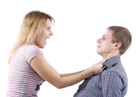 young woman abusing a man holding him by the shirtの写真素材