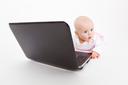 baby with laptop on a white background in studioの写真素材