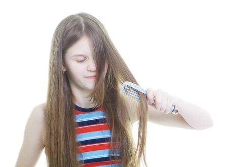 Dissatisfied with teen girl combing her long hair tangled
の写真素材