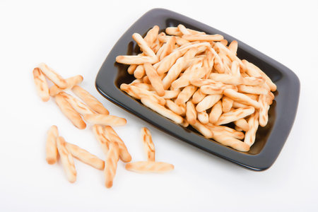 salted sticks on a plate. Snack on a white background