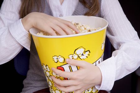 child's hand in a bucket of popcornの写真素材