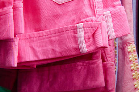 a lot of bright children's clothing on a hanger in the storeの写真素材