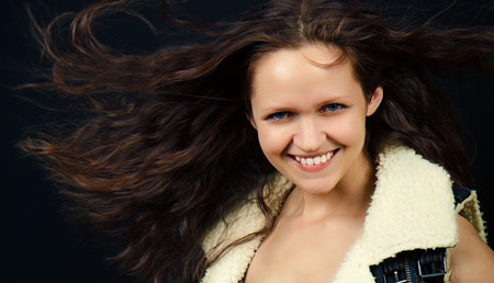 attractive girl with long hair in denim vest with fur