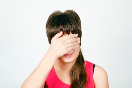 Teen girl hides her face in his handの写真素材