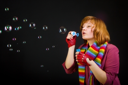 girl with soap bubbles on a black backgroundの写真素材