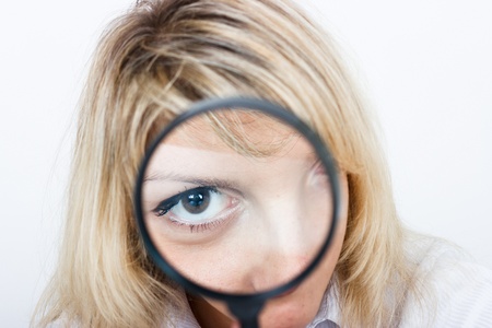 Girl is looking through a magnifying glassの写真素材