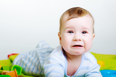Little baby boy with toys weeps