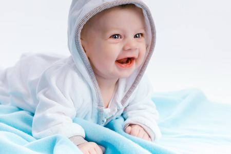 Cute baby in the hood on a blue blanketの写真素材