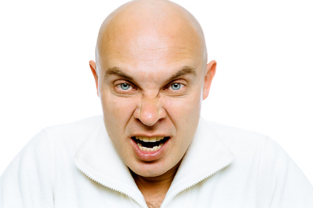 Bald man screams into the camera. Close-up. Isolated on whiteの写真素材