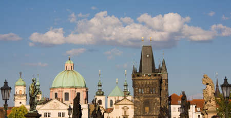 Statues on Charles bridge with New Town towers in Prague.の写真素材