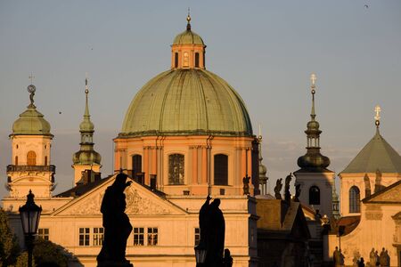 Statues on Charles bridge with New Town towers in Prague.の写真素材