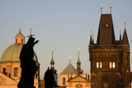 Statues on Charles bridge with New Town towers in Prague.の写真素材