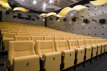 Empty cinema auditorium with line of yellow chairs.の写真素材