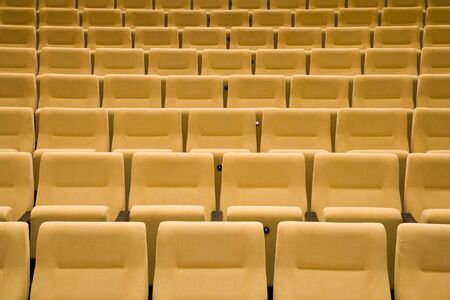 Empty cinema auditorium with line of yellow chairs.の写真素材
