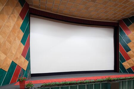 PR (property release) available. Empty cinema auditorium with line of chairs and projection screen. Ready for adding your own picture. Side view.の写真素材