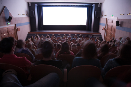 Cinema auditorium with people in chairs watching movie performance. Ready for adding your own picture.の写真素材