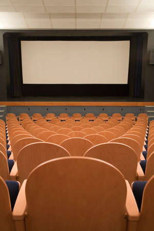 PR (property release) available. Empty cinema auditorium with line of chairs and projection screen. Ready for adding your own picture. Front view.の写真素材